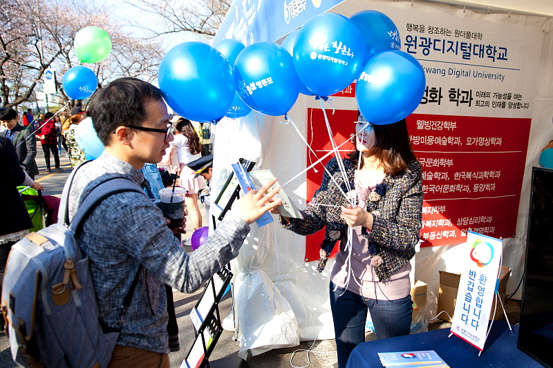 원광디지털대학교 홍보부스를 방문한 시민들에게 풍선과 리플렛을 나눠주는 모습