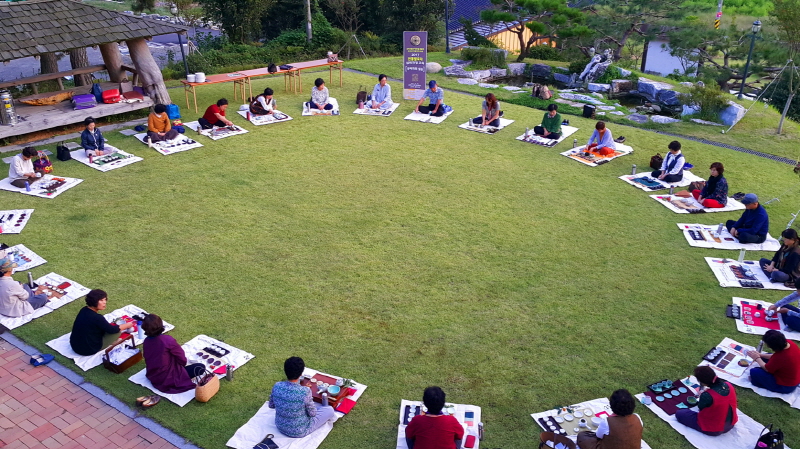 실습 교육을 위해 잔디밭에 여러명이 둘러앉아 있는 모습